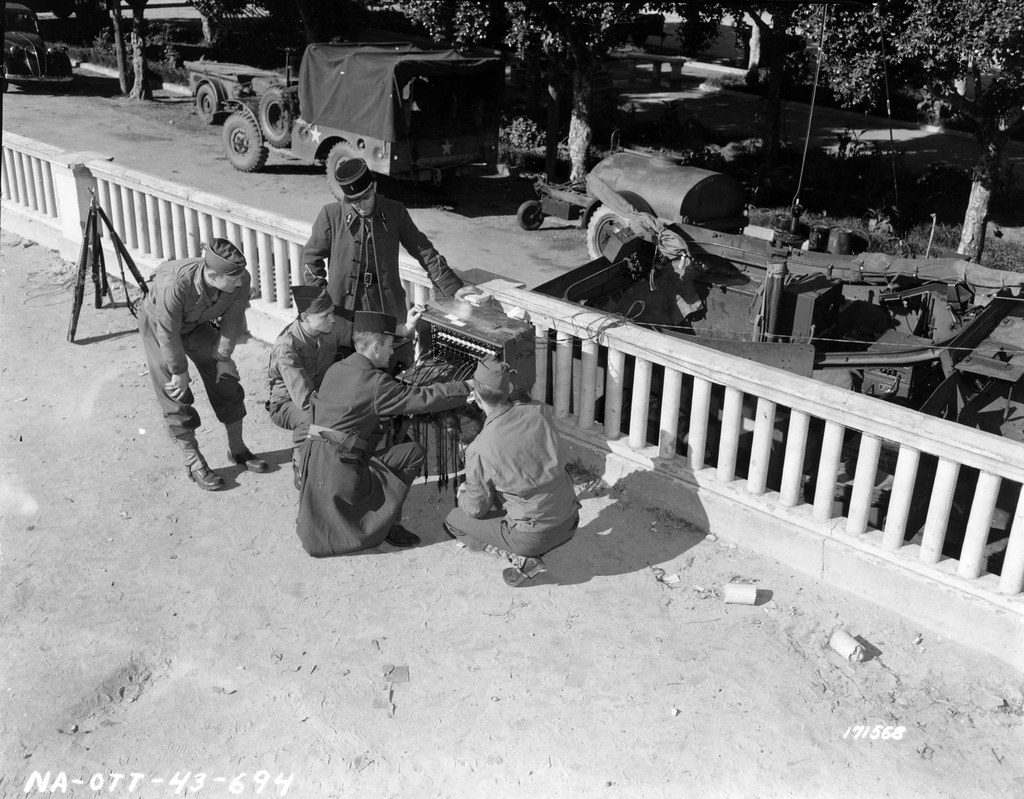 SC 171568 - American soldiers teach the French the use of BD-72 common battery switchboard. In background an M1 Scout Car with transmitter. Near Algiers, North Africa. 9 February, 1943.