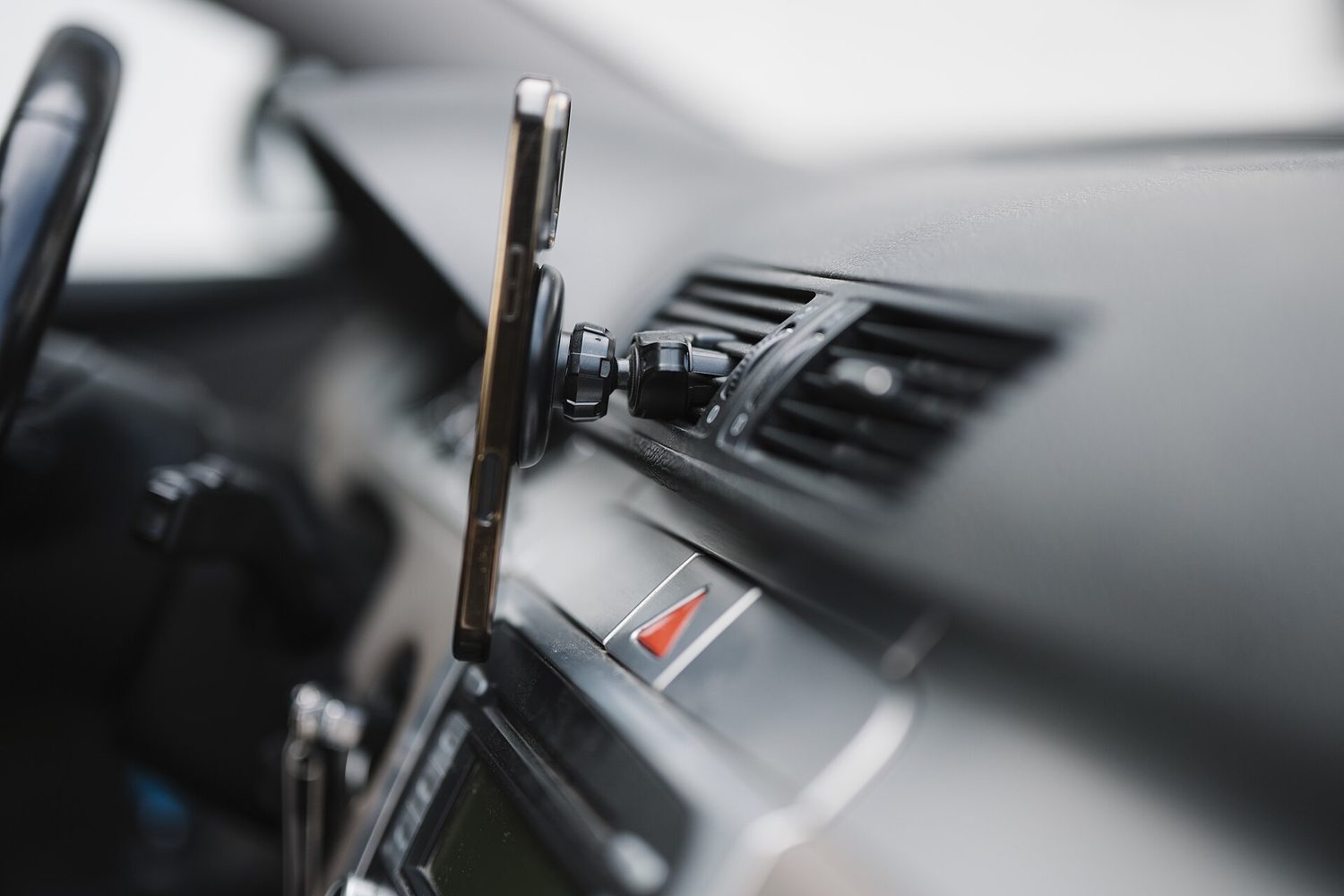 Smartphone mounted on car dashboard during a drive in a modern vehicle with a focus on navigation use