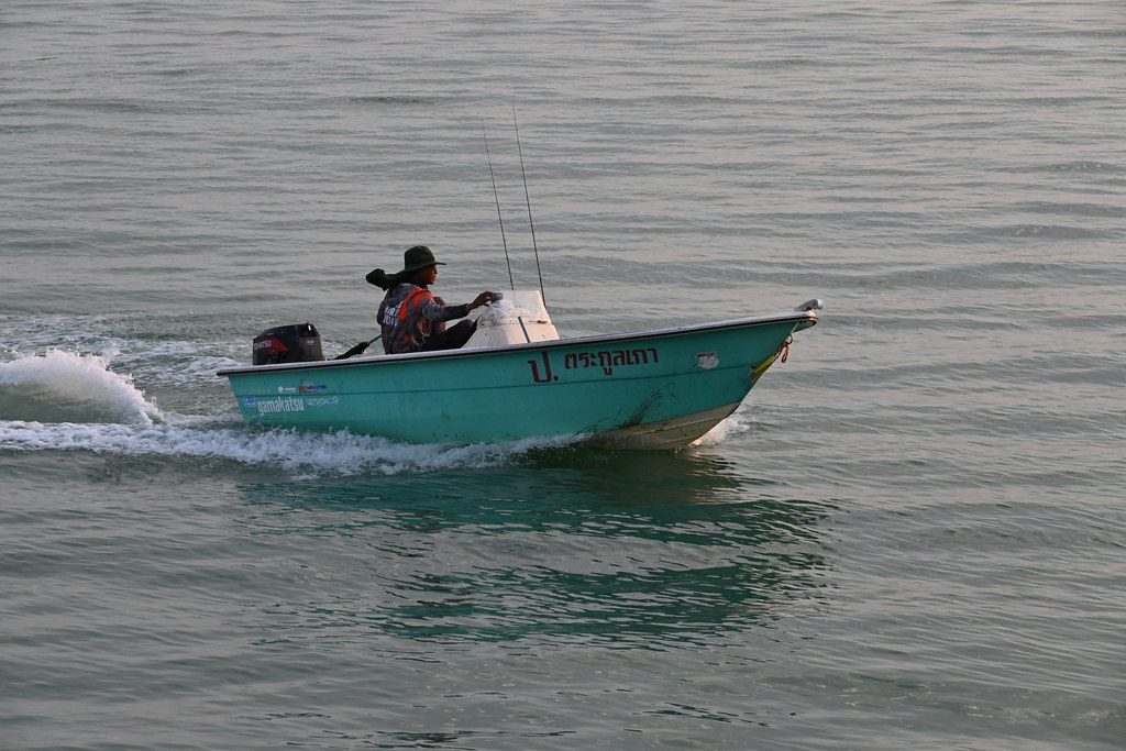DSC_9611: a man in a blue boat on the water