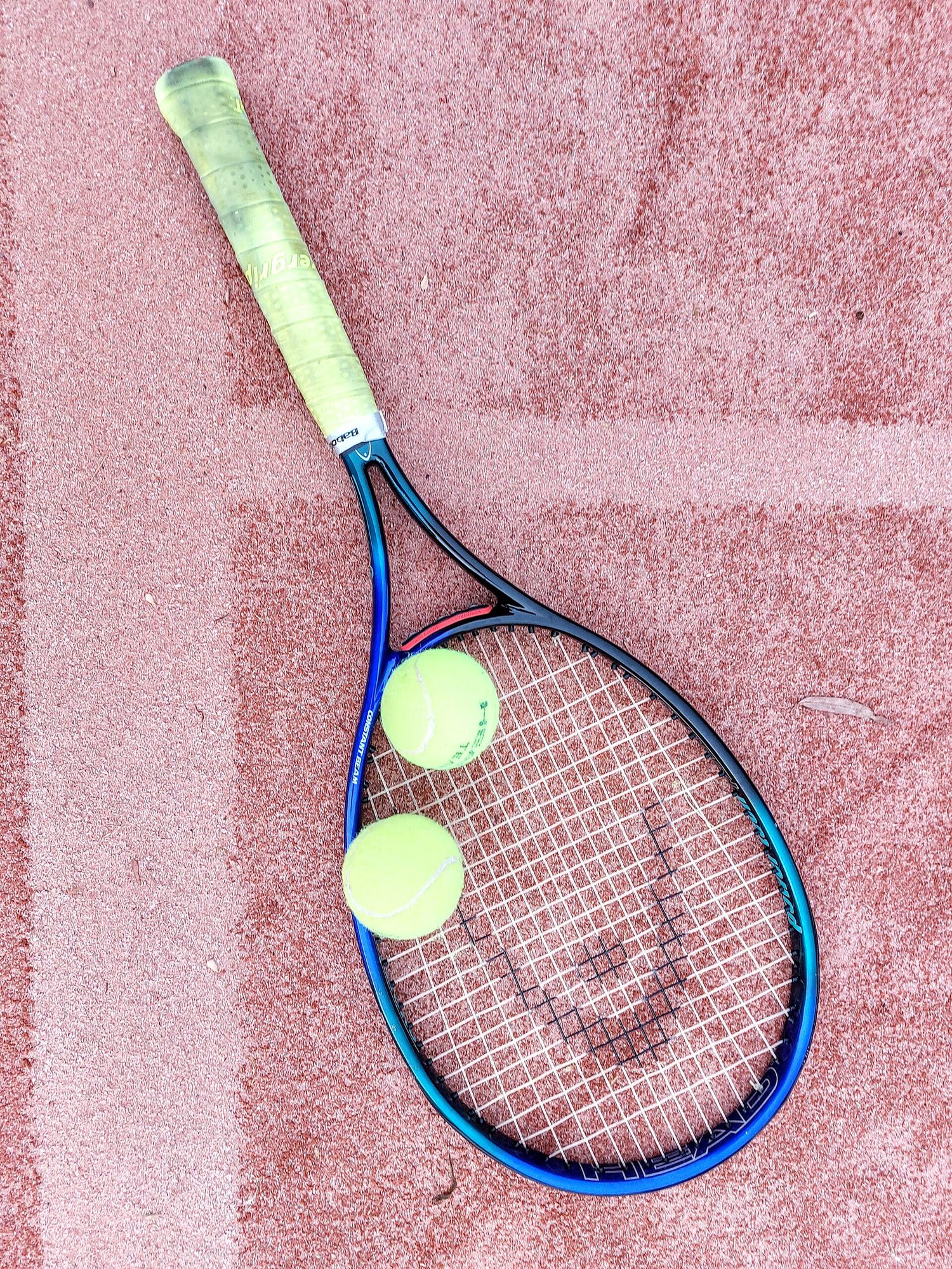 Tennis Racquets and Balls on a Clay Court