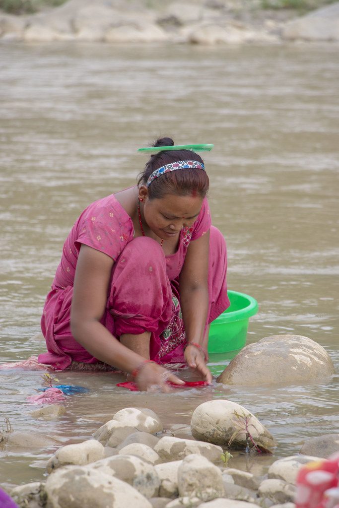 Nepali woman washes clothes in the Babai River