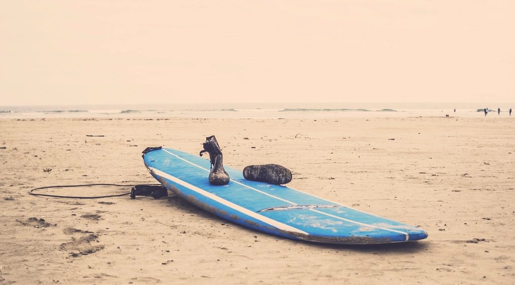 Blue surfboard sandy beach